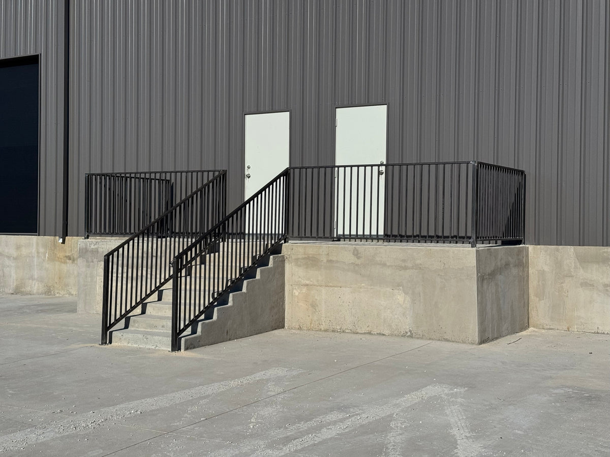 Welded steel stair railing and guard rail on a commercial loading dock, fabricated and installed by Prestigious Metal Works, Waco TX