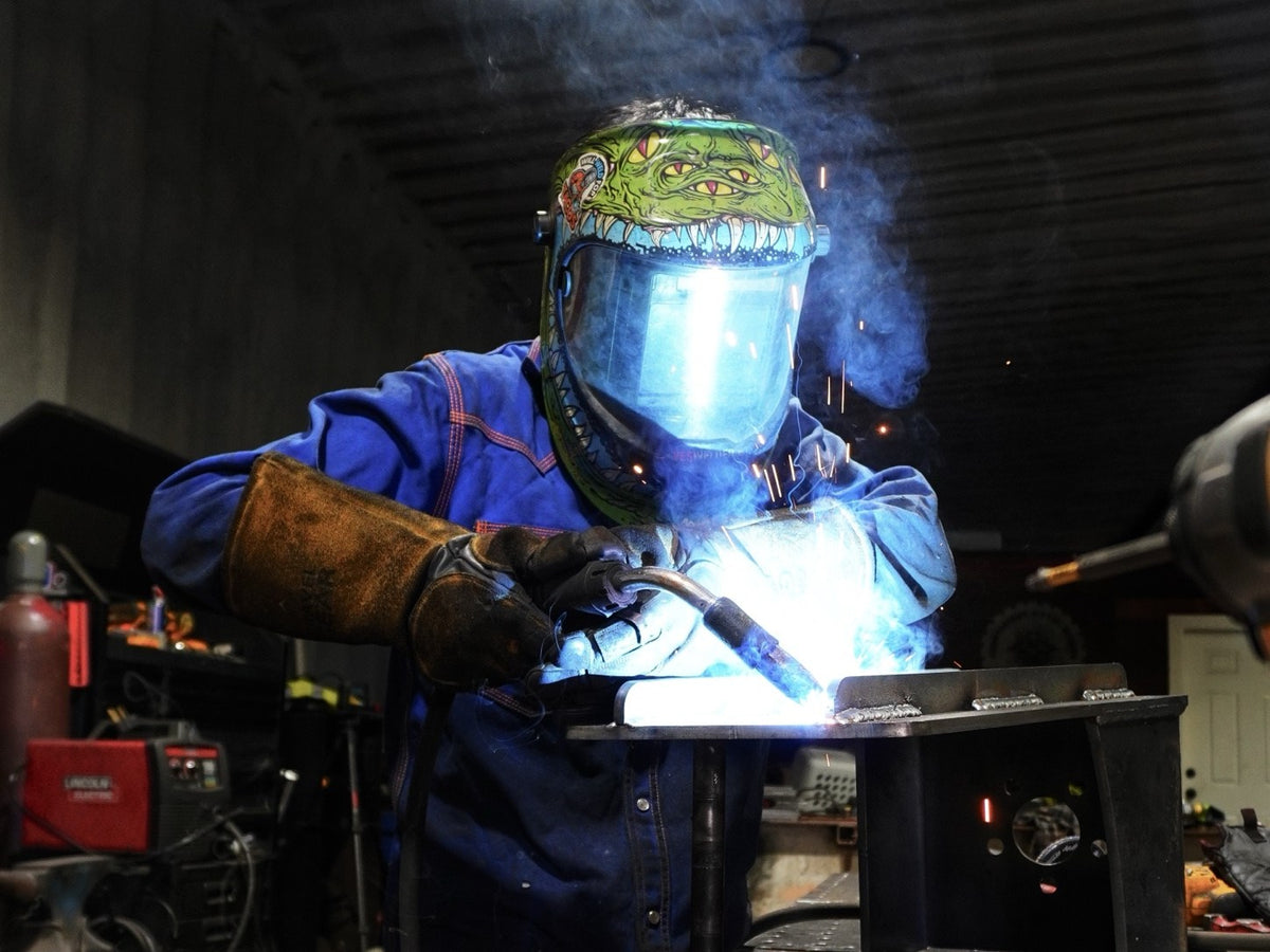 Prestigious Metal Works welder MIG welding a custom steel bracket on the fabrication table in Waco, TX